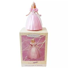 a pink princess figurine sitting on top of a box