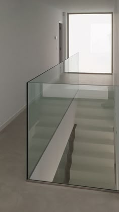 an empty room with glass balustrades on the floor and stairs leading up to it