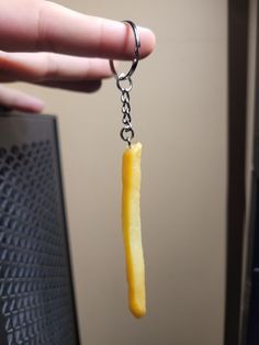 a piece of fruit is being held by a person's hand with a chain