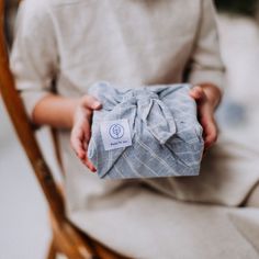 a person sitting in a chair holding a wrapped present