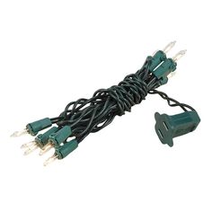 green christmas lights with white wire and plugs on a white background, close up