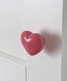 a heart shaped doorknob on a white cabinet