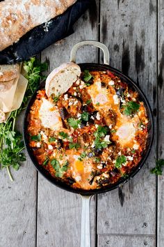 an iron skillet filled with food and garnished with parmesan cheese