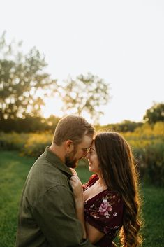 a man and woman standing next to each other in the grass