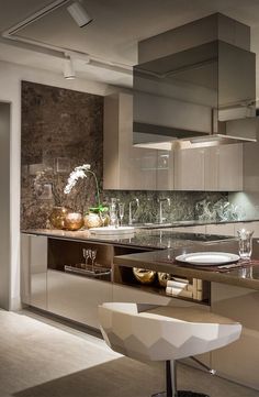 a modern kitchen with stainless steel appliances and marble counter tops