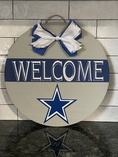 a sign that says welcome with a star on it and a bow at the top