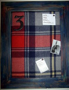 an old frame is decorated with plaid fabric and some photos are pinned to the wall