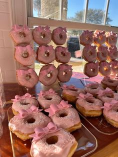 there are many donuts on the table and one is decorated with pink icing