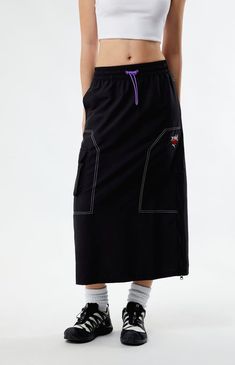 Unleash a fusion of sporty and chic with the Puma x X-Girl Midi Skirt. This collaboration piece effortlessly blends Puma's athletic aesthetic with X-Girl's streetwear flair, resulting in a stylish midi skirt that's both comfortable and on-trend. Crafted with a lightweight woven fabric, this midi skirt has an adjustable drawcord waist, cargo side pockets, a zipper side closure, and contrast stitching for a touch of boldness.


	32" center front length
	Can be worn low or high on the waist
	Lightweight woven fabric
	Contrast stitching
	Cargo side pockets
	Logo embroidery
	Side zipper closrue
	Model is wearing a size small
	Model measurements: 5’8.5” height, 31.5” bust, 24” waist, 35.5” hips Stylish Midi Skirt, Athletic Aesthetic, Girls Streetwear, Summer Streetwear, Puma X, Midi Skirts, Logo Embroidery, Contrast Stitch, Sewing Ideas