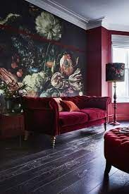 a living room with red couches and floral wallpaper on the walls in front of a window