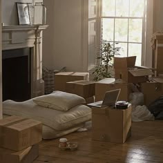 a living room filled with lots of boxes on the floor next to a fire place