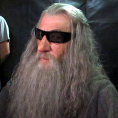 an old man with long grey hair and sunglasses on sitting in front of a camera