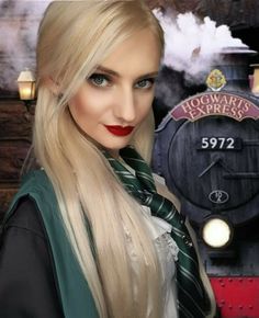 a woman with long blonde hair wearing a harry potter costume and posing in front of a hogwarts express train