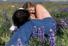 two people are sitting in a field of purple flowers