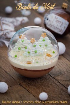 a bowl filled with white chocolate and green candies on top of a wooden table