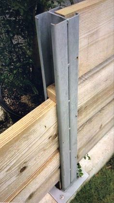 a piece of wood that has been placed on the side of a building with some metal bars attached to it