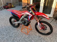 a red dirt bike sitting on top of a metal stand