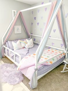 a child's bed with pink and blue canopy