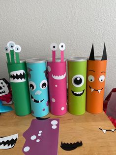 several different colored paper cups with monster faces on them