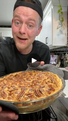 a man holding up a pizza in front of his face and making a funny face