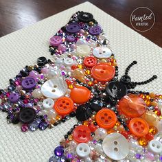 a butterfly made out of buttons sitting on top of a table