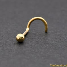 a gold nose ring on a black surface