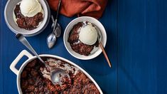 two white bowls filled with chili and ice cream on top of a blue wooden table