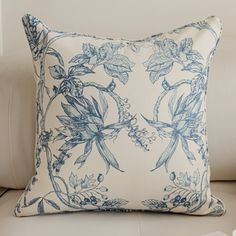 a blue and white pillow sitting on top of a couch