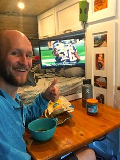 a man sitting at a table with a bowl of food in front of his face