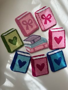 small crocheted books with hearts and ribbons on them are arranged in the shape of rectangles