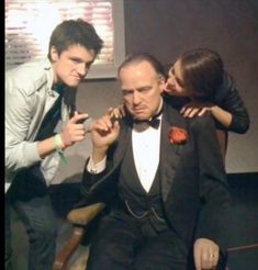 two men and a woman are getting ready to wear tuxedos for an event