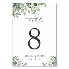 the table number 8 with eucalyptus leaves and greenery on it is shown in black ink