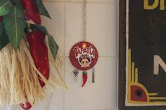 a clock hanging from the side of a wall next to a potted plant and sign