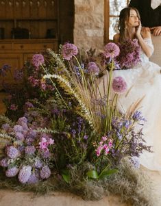 a bride and groom are sitting on the floor with flowers in front of their faces