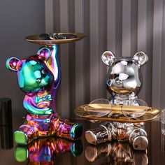 two colorful glass bears sitting on top of each other next to a table with drinks