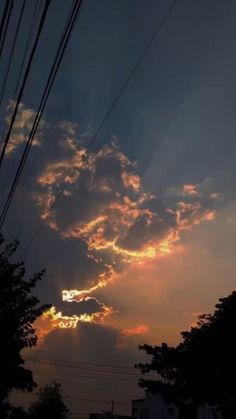 the sun is setting behind some power lines