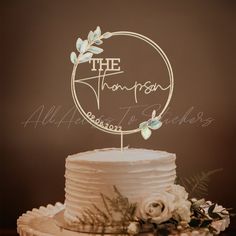 a wedding cake topper that says the honeymoon on it with flowers and greenery