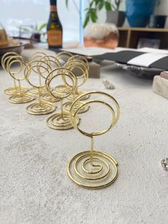 a table topped with lots of gold metal rings on top of a white cloth covered table