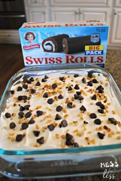 a glass baking dish filled with ice cream and chocolate chips next to a box of swiss rolls