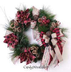 a christmas wreath with pine cones and ribbons