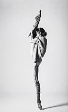 a black and white photo of a woman doing a dance move with her leg in the air