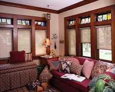 a living room filled with lots of furniture and windows covered in blind shades next to a couch