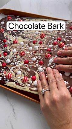 someone is decorating a chocolate bar with red and white decorations