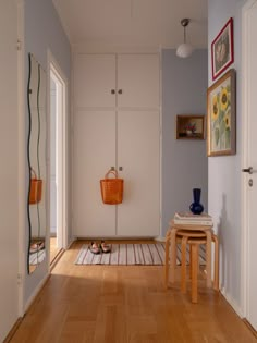 a hallway with wooden floors and white walls