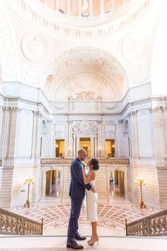 a bride and groom standing in the middle of a building