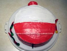 a cake with white and red frosting in the shape of a ball on a plate