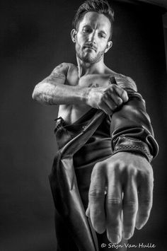 a shirtless man is pointing his finger at the camera while posing for a black and white photo