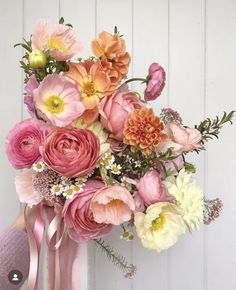 a pink vase filled with lots of different colored flowers