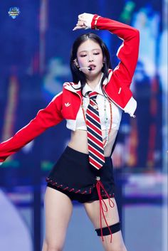 a woman in a red and white uniform with her arms up while standing on stage