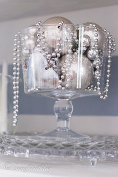 a glass bowl filled with ornaments on top of a table